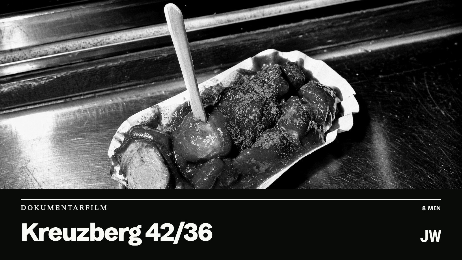 Vorschaubild: Nahaufnahme einer Currywurst in einer Pappschale auf einem Stahltresen, darunter im schwarzen Band der Titel Kreuzberg 42/36. Foto KI-generiert.